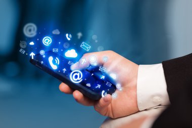 İşadamı medya simgeleriyle akıllı telefon tutuyor