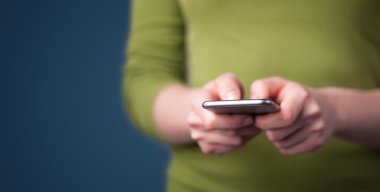 Akıllı telefonu elinde tutan genç bir kadın. 