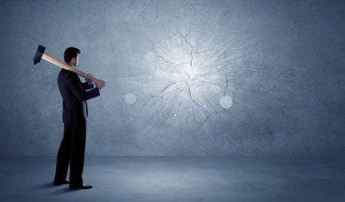 İşadamı çekiçle duvara çarpıyor.