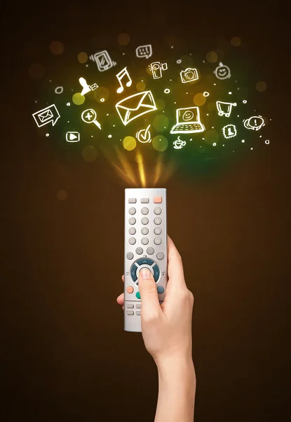 Hand with remote control and social media icons — Stock Photo, Image