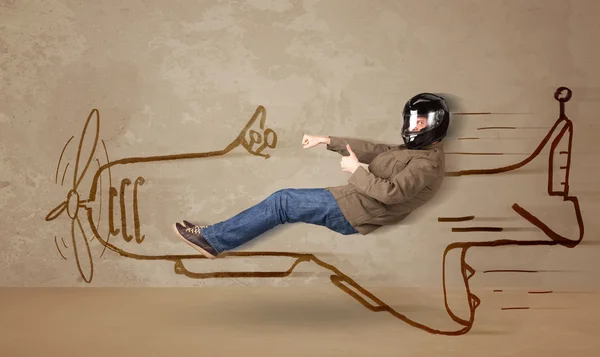 Funny pilot driving a hand drawn airplane on the wall — Stock Photo, Image