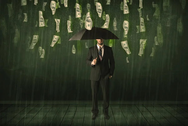 Businessman standing with umbrella in dollar bill rain concept — Stock Photo, Image