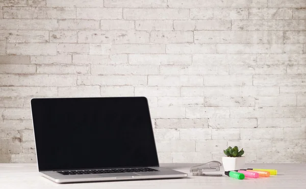 Бізнес ноутбук з білою цегляною стіною — стокове фото
