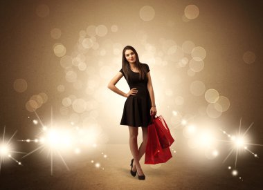 Parlak ışıklarda çantalı alışveriş yapan kadın.