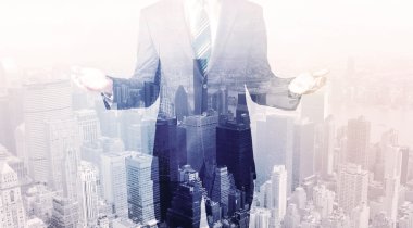 İş adamı çatıda duruyor ve arka planda şehir var.