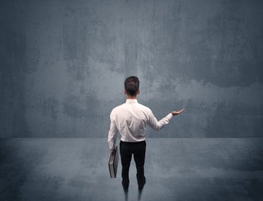 Şehir duvarının önünde duran iş adamı