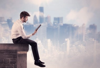 Yüksek bir binanın tepesinde oturan satıcı.