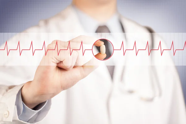 A doctor  holding a heart pill — Stock Photo, Image