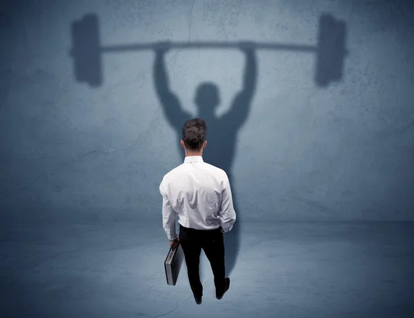 Businessman with weight lifting shadow — Stock Photo, Image