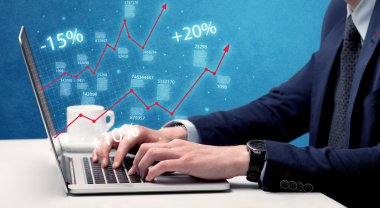 Satıcı dizüstü bilgisayarla grafikle çalışıyor.