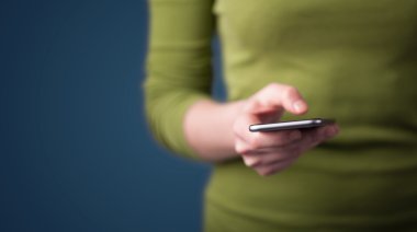 Akıllı telefonu elinde tutan genç bir kadın. 