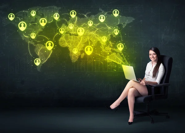 Businesswoman in office with laptop and social network world map — Stock Photo, Image