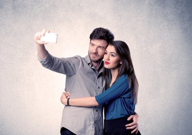 Mutlu çift temiz duvarlı selfie çekiyor.