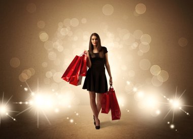 Parlak ışıklarda çantalı alışveriş yapan kadın.