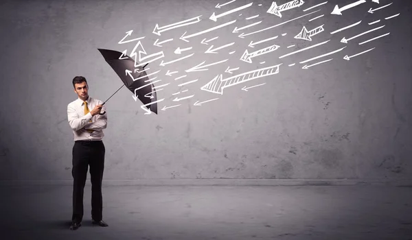 Business man standing with umbrella and drawn arrows hitting him — Stock Photo, Image