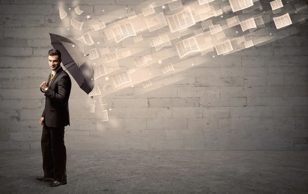 Uomo d'affari che protegge con ombrello contro vento di carte — Foto Stock