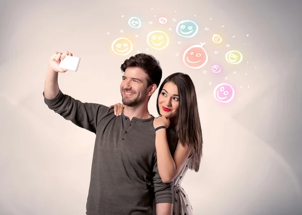 Pareja feliz tomando selfie con smiley — Foto de Stock