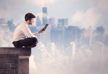 Yüksek bir binanın tepesinde oturan satıcı.