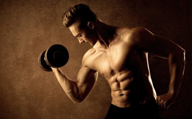 Kas formundaki vücut geliştirici sporcu ağırlık kaldırıyor 