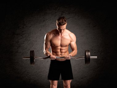 Seksi halterci adam kaslarını gösteriyor.