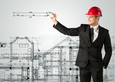 Genç bir mimar ev planı çiziyor.