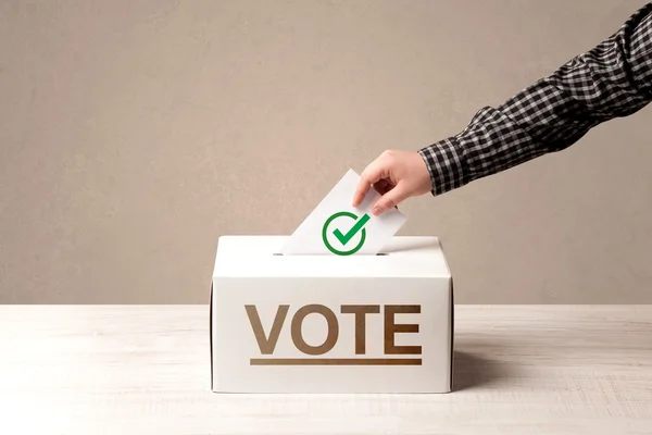 Fechar a mão masculina colocando voto em uma urna — Fotografia de Stock