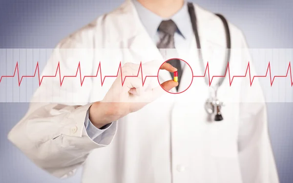 Un médecin tenant une pilule cardiaque — Photo