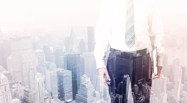 Business man standing on roof with city in the background — Stock Photo, Image