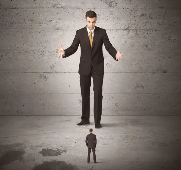 Büyük bir iş adamı küçük bir iş arkadaşına bakıyor.
