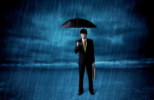 Ділова людина стоїть під дощем з парасолькою — стокове фото