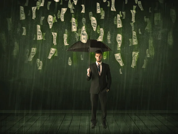 Biznesmen stojący z parasolem w dolarach koncepcja deszczu — Zdjęcie stockowe