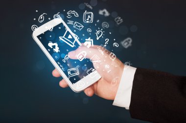 Medya simgeleri ve sembolleriyle el ele tutuşan akıllı telefon 