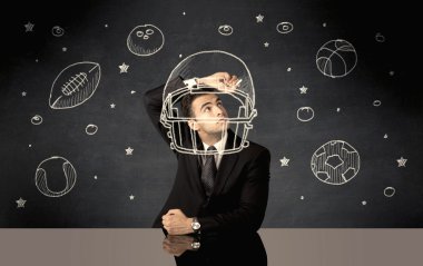 İş adamı miğfer ve spor topu çiziyor.