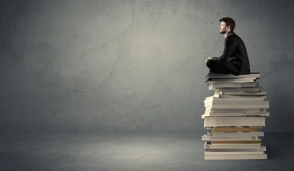 Homme élégant assis sur des livres — Photo