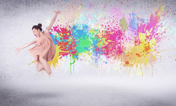 Modern street dancer jumping with colorful paint splashes — Stock Photo, Image