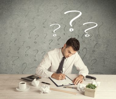 İş adamı soru işaretiyle masada.