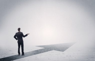 Ayakta duran satıcı elinde okla ileriye bakıyor.