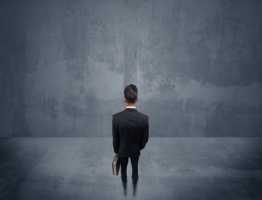 Şehir duvarının önünde duran iş adamı