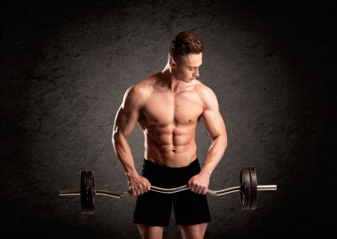Seksi halterci adam kaslarını gösteriyor.