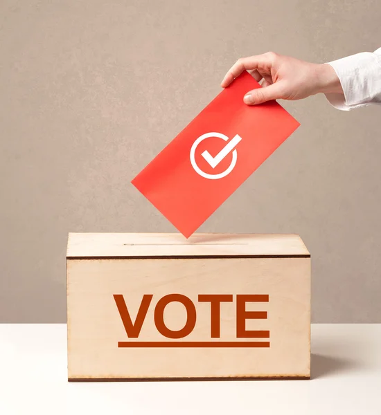 Fechar a mão masculina colocando voto em uma urna — Fotografia de Stock