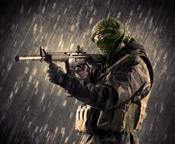 Uomo armato terrorista con maschera su sfondo piovoso — Foto Stock