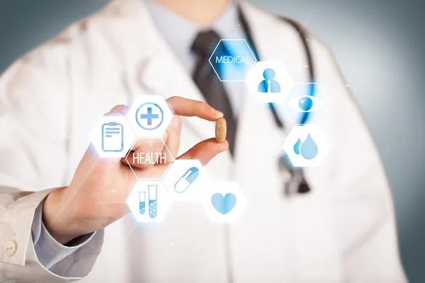 A doctor in white holding a pill — Stock Photo, Image