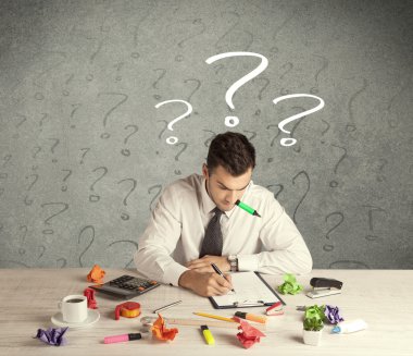 İş adamı soru işaretiyle masada.