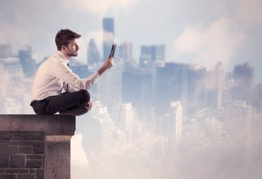 Yüksek bir binanın tepesinde oturan satıcı.