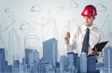 Genç işçi şehir manzarası çiziyor.