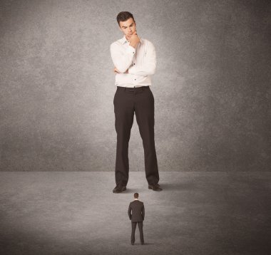 Büyük iş adamı küçük işçilere bakıyor.