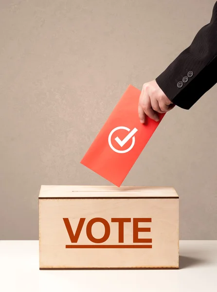 Fechar a mão masculina colocando voto em uma urna — Fotografia de Stock