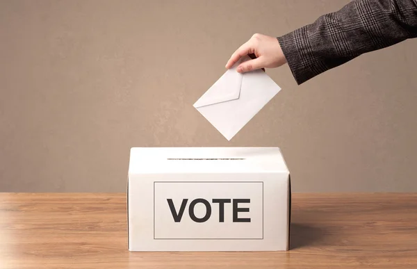 Close up of male hand putting vote into a ballot box — Stock Photo, Image