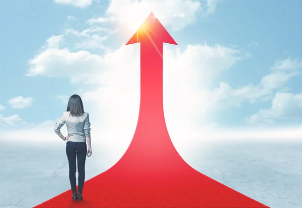 Businesswoman standing on a red arrow — Stock Photo, Image