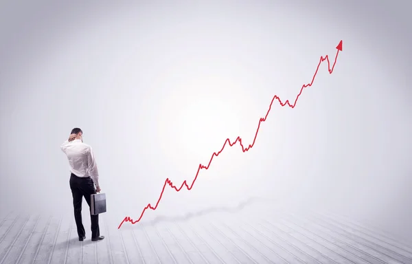 Hombre de negocios de pie con flecha de gráfico rojo — Foto de Stock